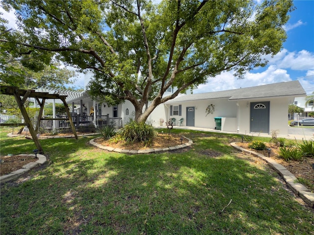 75 N Canal Dr, Palm Harbor, FL 34684 - view of front of house featuring a pergola, a front yard, and stucco siding