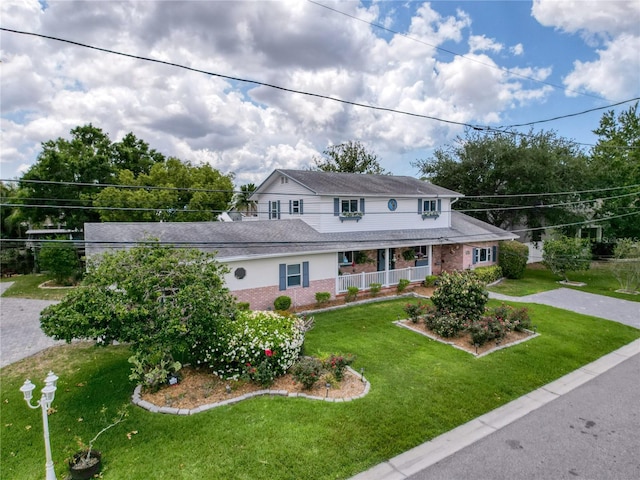 75 N Canal Dr, Palm Harbor, FL 34684 - country-style home featuring a porch, brick siding, and a front yard