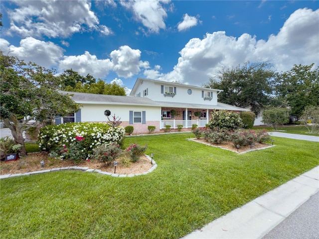 75 N Canal Dr, Palm Harbor, FL 34684 - view of front of home featuring a porch, brick siding, and a front yard