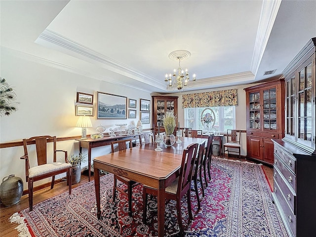 75 N Canal Dr, Palm Harbor, FL 34684 - dining space with visible vents, ornamental molding, a tray ceiling, dark wood finished floors, and a notable chandelier
