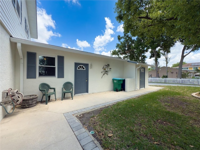 75 N Canal Dr, Palm Harbor, FL 34684 - doorway to property with a patio, stucco siding, and fence