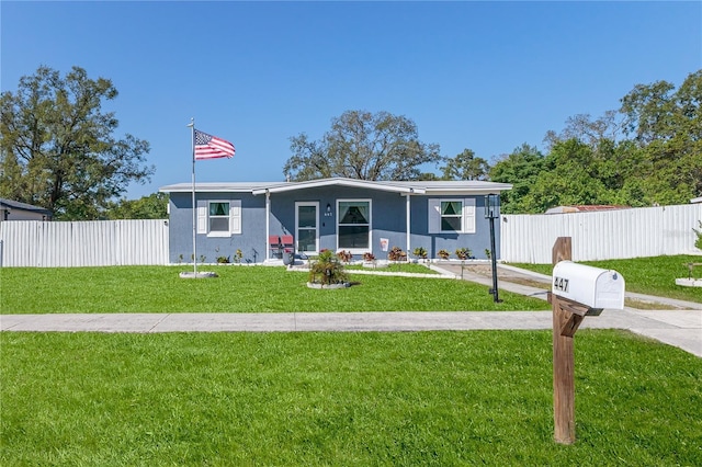 view of front of home with stucco siding, a front lawn, and fence