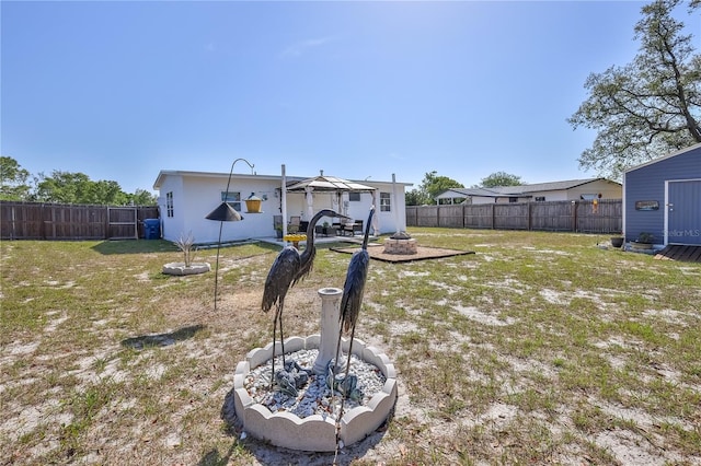 view of yard featuring a fire pit and a fenced backyard