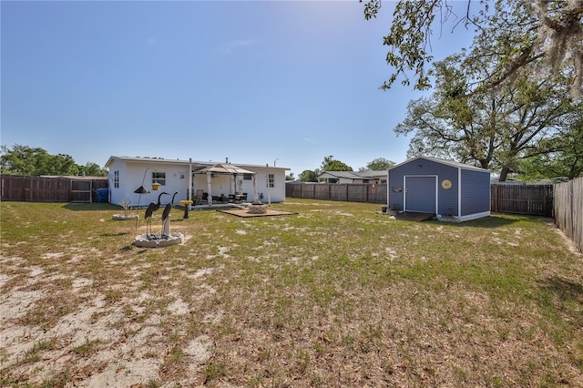 view of yard featuring a storage shed, a patio, an outbuilding, and a fenced backyard