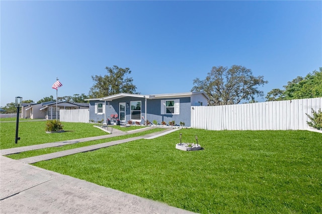 view of front of home with fence, stucco siding, and a front yard