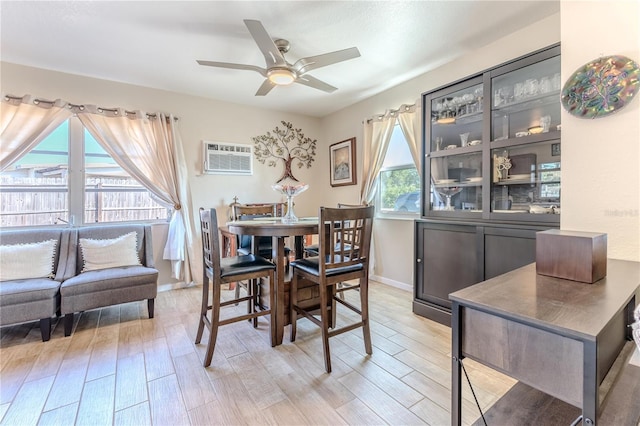dining room with light wood-style floors, baseboards, ceiling fan, and a wall mounted AC