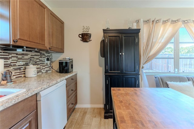 kitchen featuring backsplash, dishwasher, baseboards, light wood finished floors, and butcher block countertops