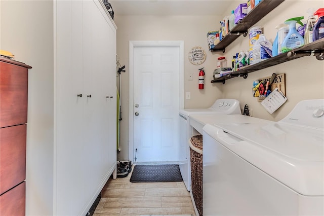 laundry room with laundry area, light wood-type flooring, and washer and clothes dryer