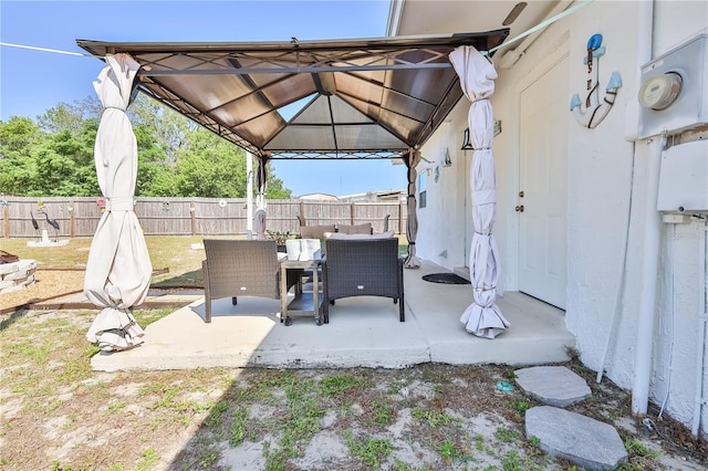 view of patio with a fenced backyard, outdoor dining space, and a gazebo