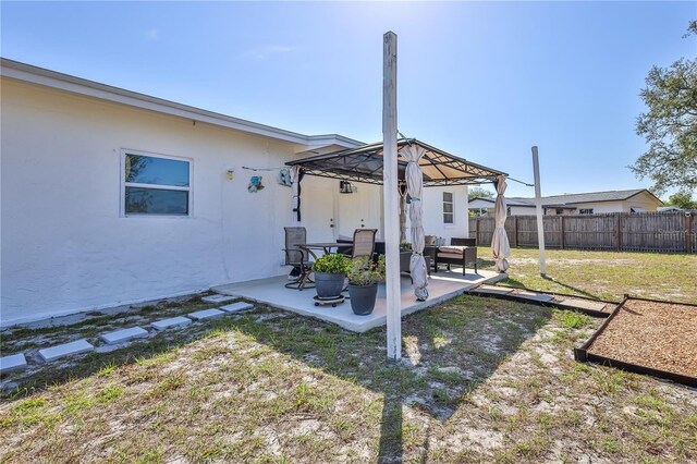 view of yard featuring a patio, a gazebo, and a fenced backyard