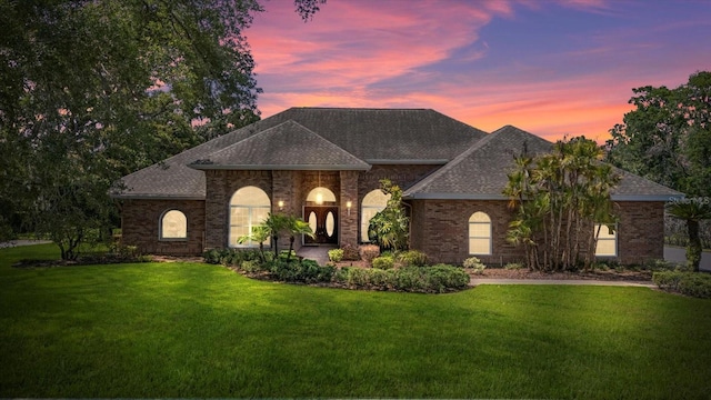 888 Royal Birkdale Dr, Tarpon Springs, FL 34688 - view of front of home featuring brick siding, a shingled roof, and a front yard