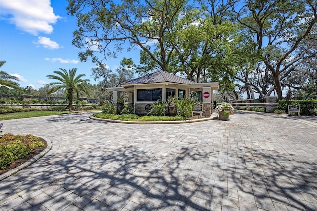 888 Royal Birkdale Dr, Tarpon Springs, FL 34688 - view of front of property with a standing seam roof, fence, driveway, and stone siding