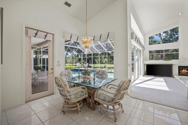 888 Royal Birkdale Dr, Tarpon Springs, FL 34688 - dining room featuring a healthy amount of sunlight, high vaulted ceiling, an inviting chandelier, and visible vents