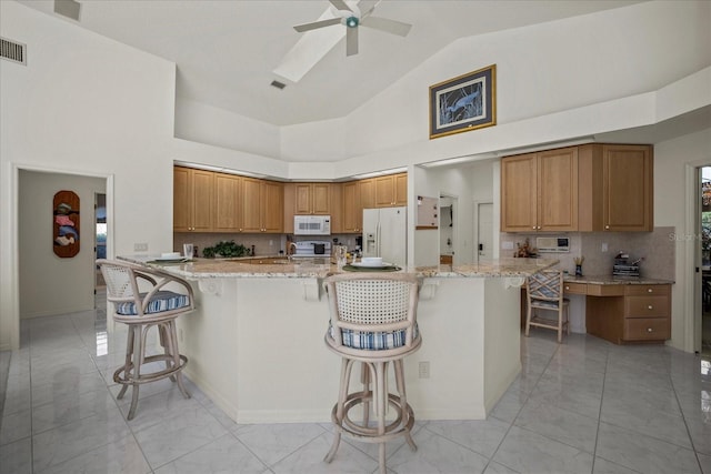 888 Royal Birkdale Dr, Tarpon Springs, FL 34688 - kitchen with a ceiling fan, a kitchen bar, light stone countertops, marble finish floor, and white appliances