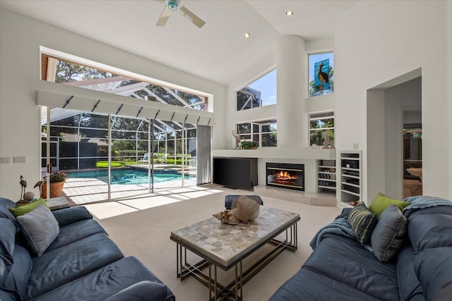 888 Royal Birkdale Dr, Tarpon Springs, FL 34688 - carpeted living room featuring a fireplace, high vaulted ceiling, a sunroom, a ceiling fan, and recessed lighting