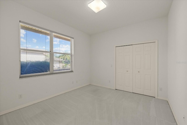 888 Royal Birkdale Dr, Tarpon Springs, FL 34688 - unfurnished bedroom with baseboards, a closet, and light colored carpet