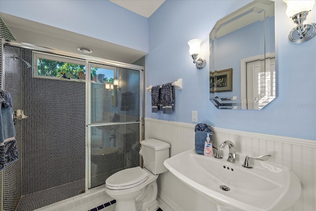 888 Royal Birkdale Dr, Tarpon Springs, FL 34688 - full bathroom with toilet, wainscoting, a sink, and a stall shower