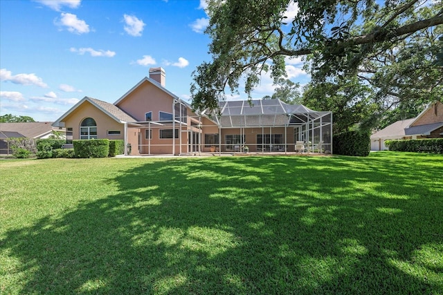 888 Royal Birkdale Dr, Tarpon Springs, FL 34688 - back of house featuring glass enclosure, stucco siding, a yard, and a chimney