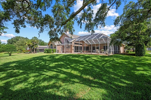 888 Royal Birkdale Dr, Tarpon Springs, FL 34688 - rear view of house featuring a yard, a chimney, and stucco siding