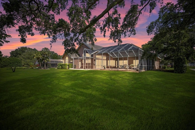 888 Royal Birkdale Dr, Tarpon Springs, FL 34688 - back of property with a lawn, a lanai, and stucco siding