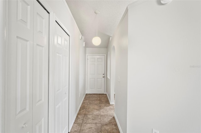 8461 Apple Orchard Rd, Spring Hill, FL 34608 - hallway featuring baseboards, a textured ceiling, and arched walkways