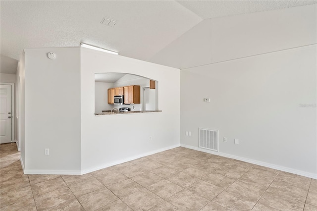 8461 Apple Orchard Rd, Spring Hill, FL 34608 - unfurnished living room with lofted ceiling, light tile patterned flooring, and a textured ceiling