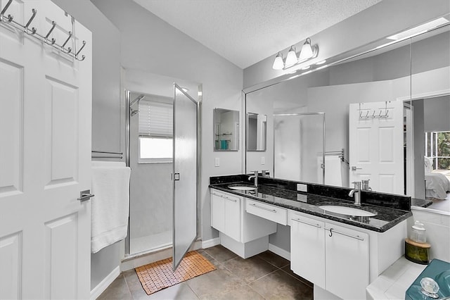 bathroom with a sink, a textured ceiling, and a shower stall