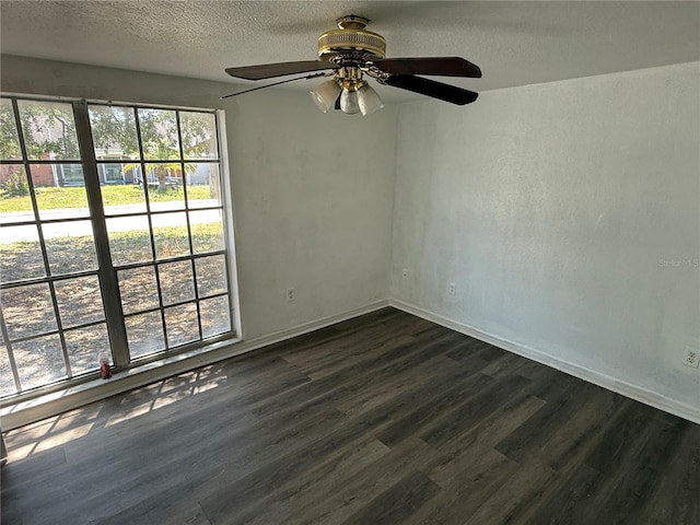 empty room with dark wood-style floors, baseboards, a ceiling fan, and a textured ceiling