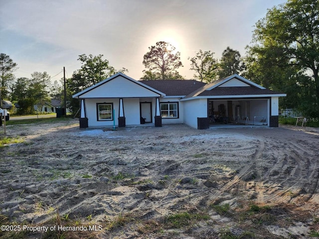 12331 Fulmar Rd, Weeki Wachee, FL 34614 - view of front of home with an attached garage, a porch, and stucco siding