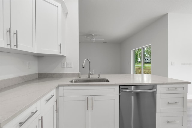 12331 Fulmar Rd, Weeki Wachee, FL 34614 - kitchen with stainless steel dishwasher, white cabinets, light stone counters, and a peninsula