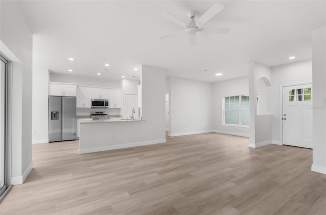 12331 Fulmar Rd, Weeki Wachee, FL 34614 - unfurnished living room featuring ceiling fan, recessed lighting, light wood-style floors, and arched walkways