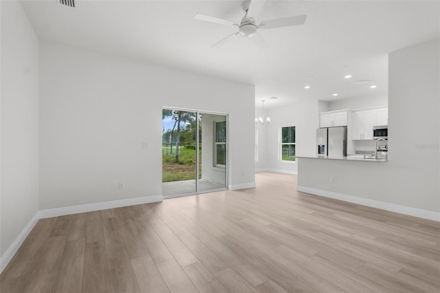 12331 Fulmar Rd, Weeki Wachee, FL 34614 - unfurnished living room featuring a chandelier, light wood finished floors, recessed lighting, and ceiling fan