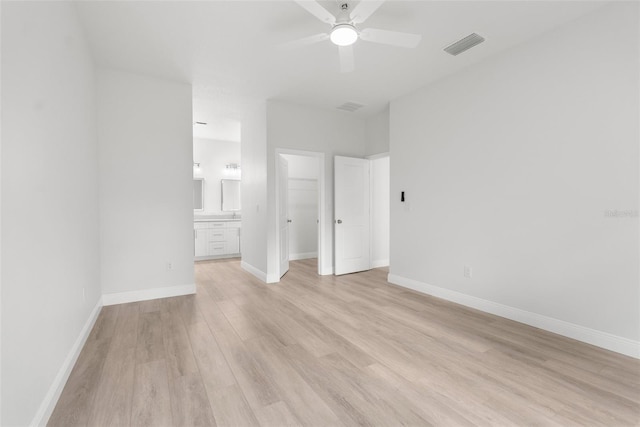 12331 Fulmar Rd, Weeki Wachee, FL 34614 - unfurnished bedroom featuring light wood-type flooring, a spacious closet, ensuite bathroom, a closet, and ceiling fan