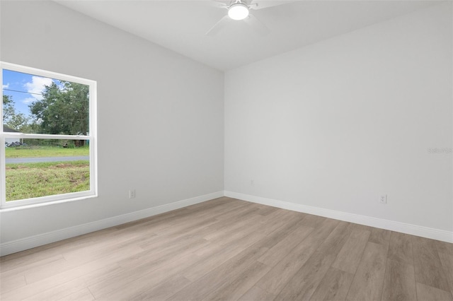 12331 Fulmar Rd, Weeki Wachee, FL 34614 - empty room with light wood finished floors, plenty of natural light, and a ceiling fan