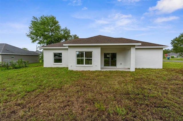 12331 Fulmar Rd, Weeki Wachee, FL 34614 - rear view of property with a lawn, stucco siding, and roof with shingles