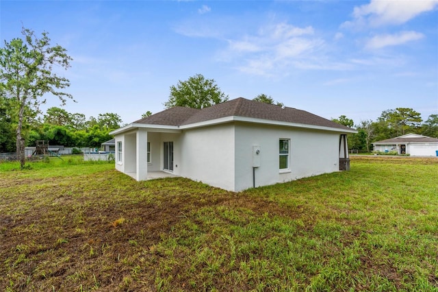 12331 Fulmar Rd, Weeki Wachee, FL 34614 - back of property featuring stucco siding and a lawn