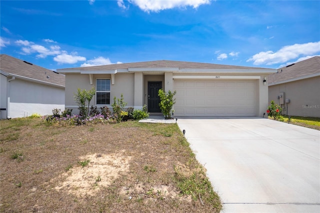 view of front of home with a garage, stucco siding, and concrete driveway