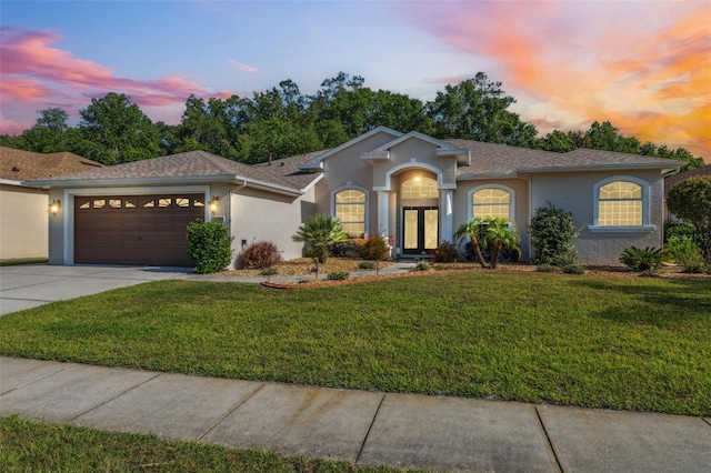 4080 Gevalia Dr, Brooksville, FL 34604 - ranch-style house featuring roof with shingles, a garage, stucco siding, a yard, and driveway