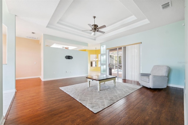 4080 Gevalia Dr, Brooksville, FL 34604 - living room featuring a ceiling fan, a tray ceiling, dark wood-style flooring, and visible vents