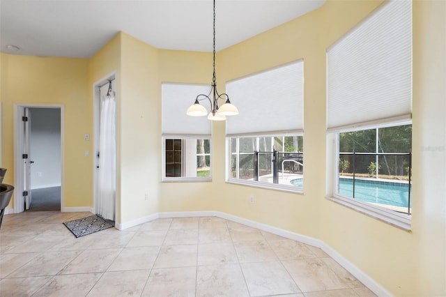 4080 Gevalia Dr, Brooksville, FL 34604 - unfurnished dining area featuring tile patterned floors, a notable chandelier, and baseboards