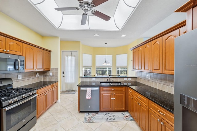 4080 Gevalia Dr, Brooksville, FL 34604 - kitchen featuring ceiling fan, backsplash, brown cabinets, a sink, and stainless steel appliances