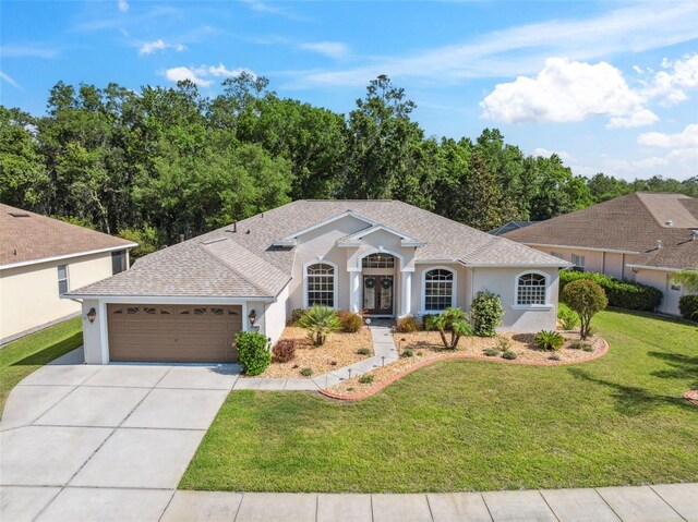 4080 Gevalia Dr, Brooksville, FL 34604 - ranch-style home with a garage, a front lawn, stucco siding, french doors, and concrete driveway