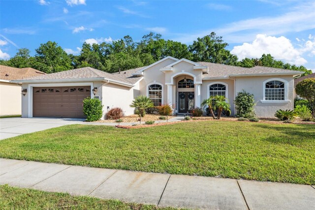 4080 Gevalia Dr, Brooksville, FL 34604 - single story home featuring a front lawn, roof with shingles, stucco siding, concrete driveway, and an attached garage