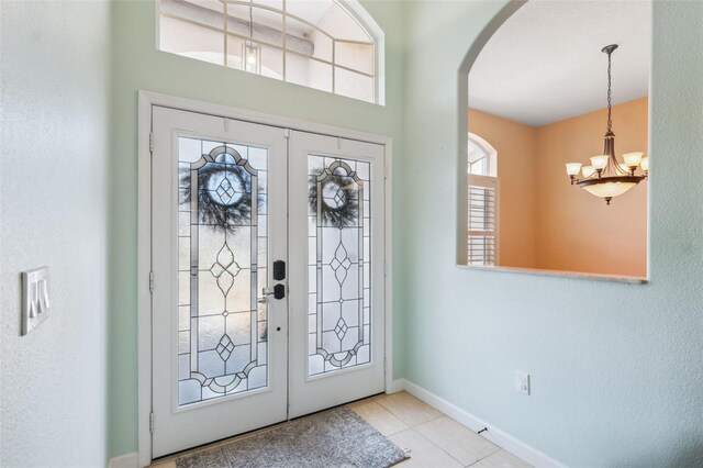 4080 Gevalia Dr, Brooksville, FL 34604 - tiled entrance foyer featuring arched walkways, baseboards, french doors, and a notable chandelier