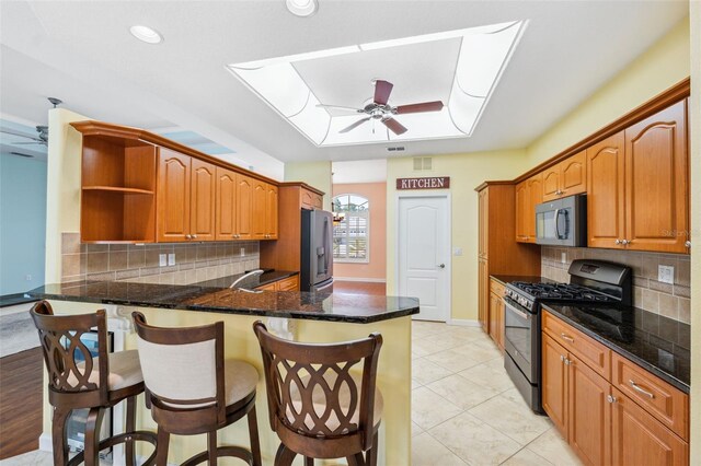 4080 Gevalia Dr, Brooksville, FL 34604 - kitchen featuring ceiling fan, open shelves, stainless steel fridge with ice dispenser, black range with gas cooktop, and a peninsula