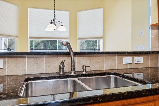 4080 Gevalia Dr, Brooksville, FL 34604 - interior details with a sink, decorative backsplash, and dark stone counters