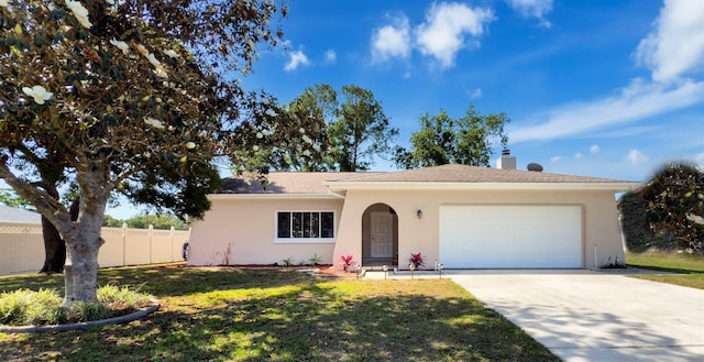 ranch-style home with a front yard, fence, concrete driveway, an attached garage, and stucco siding