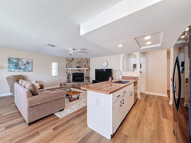 kitchen featuring light wood-type flooring, freestanding refrigerator, a sink, and open floor plan