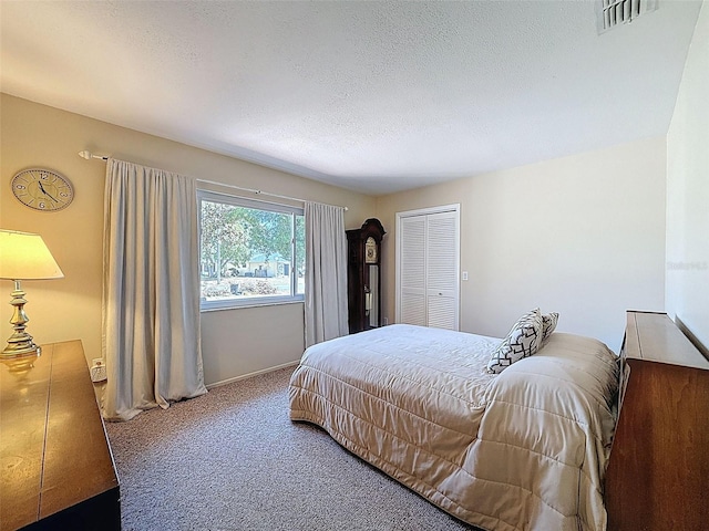 carpeted bedroom featuring a textured ceiling, visible vents, and baseboards