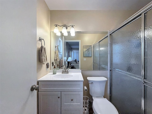 full bathroom with vanity, toilet, and a shower stall
